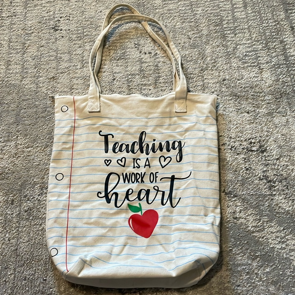 Ladies cream zipper bag w/writing that says Teaching is a work of the Heart